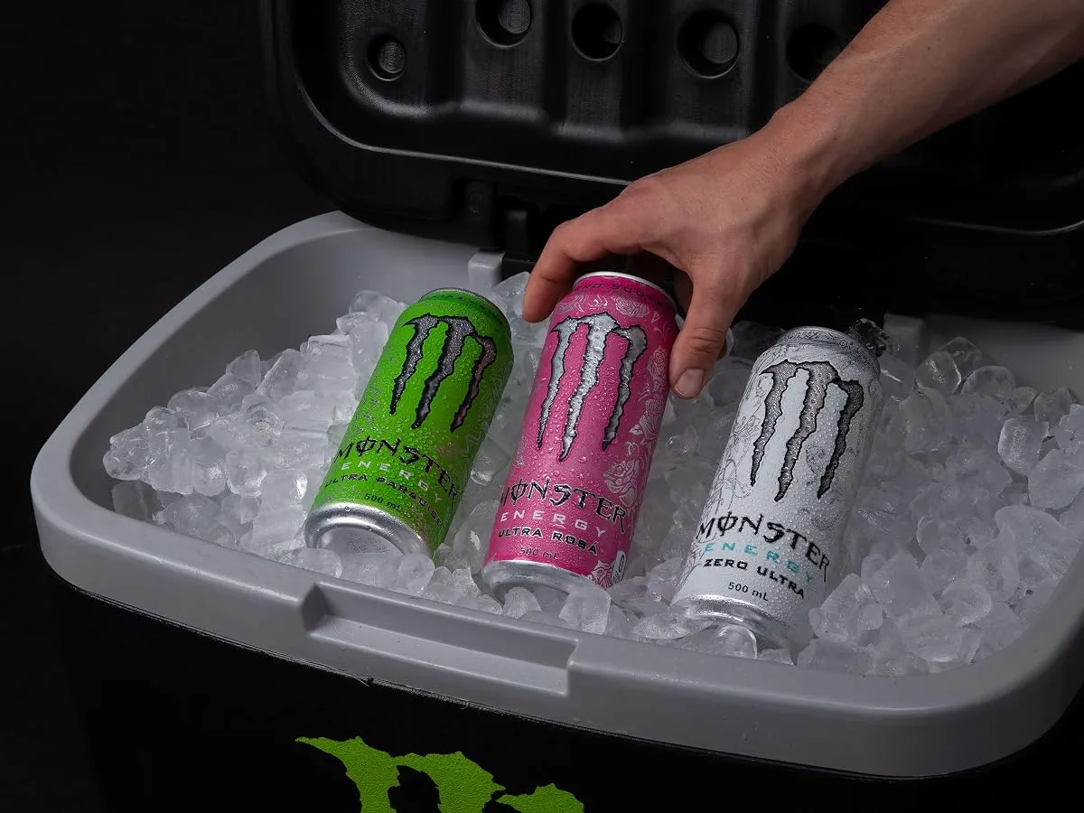 Hand pulling a chilled Monster Energy Zero Ultra can from a cooler of ice