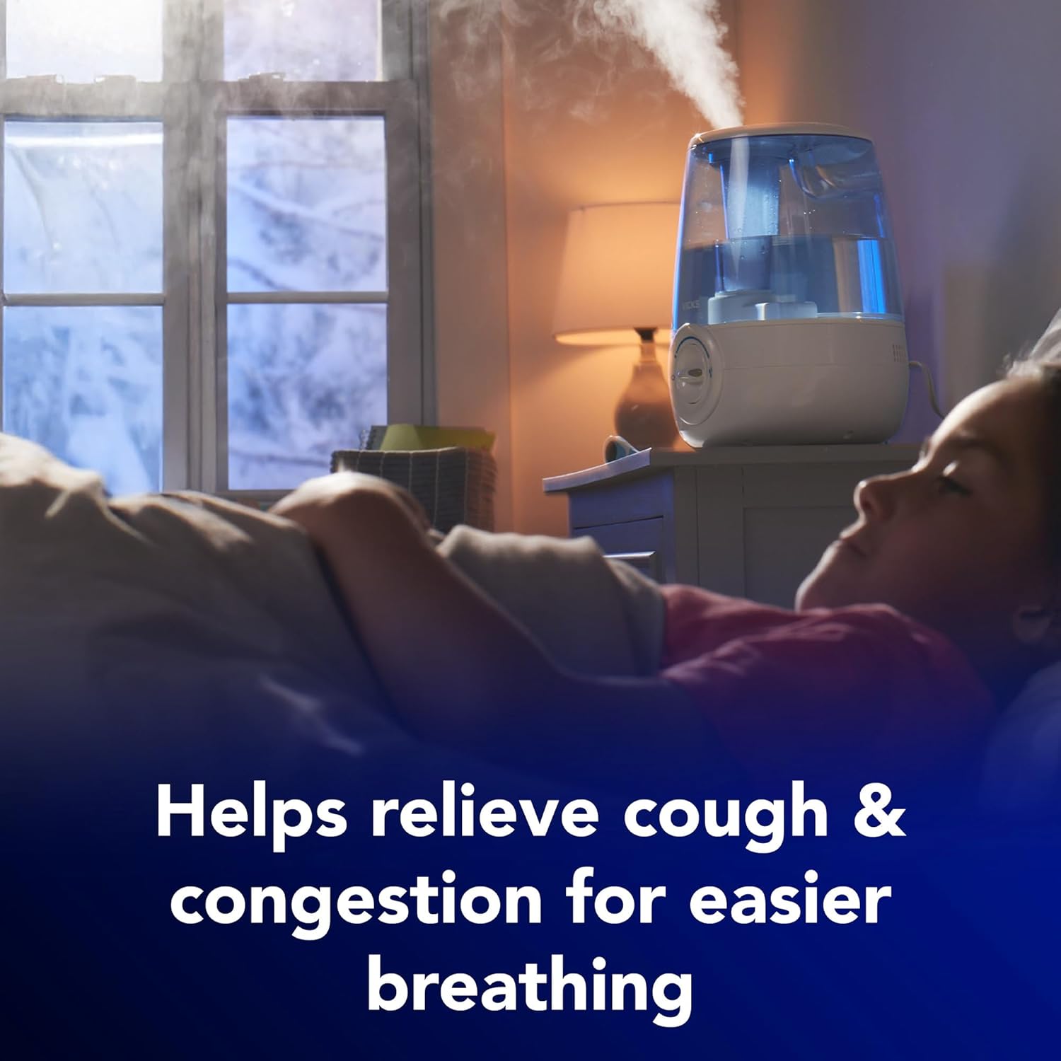 Mother and child relaxing on the floor of a nursery beside a Vicks cool mist humidifier