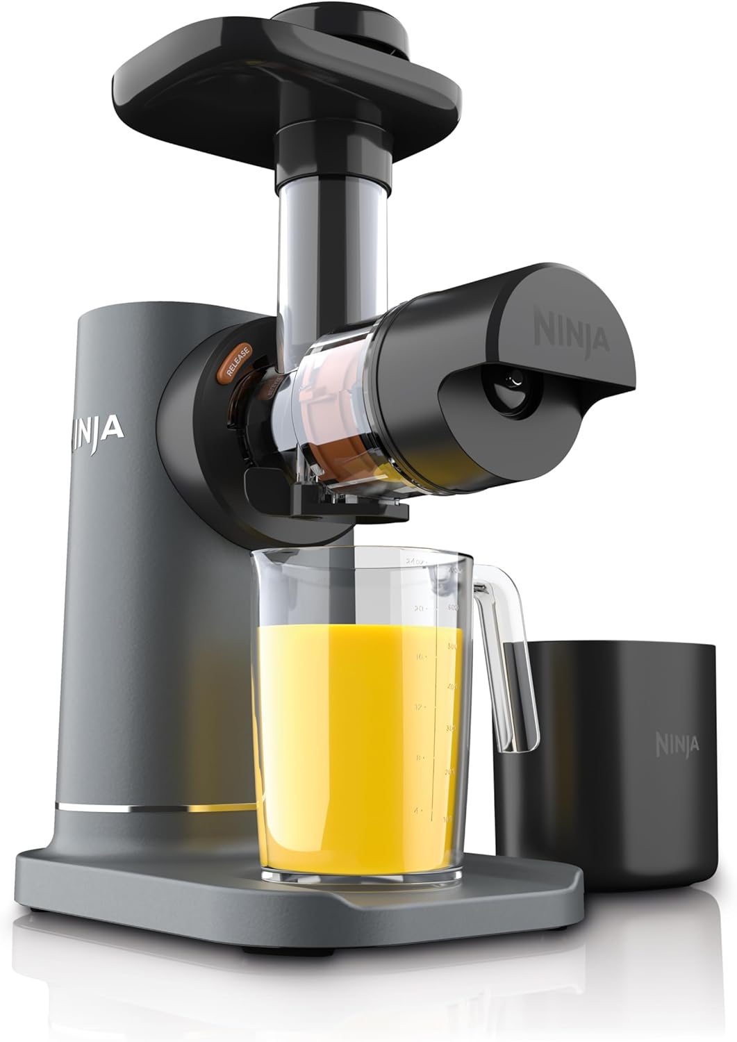Ninja NeverClog cold press juicer with a pitcher of fresh orange juice