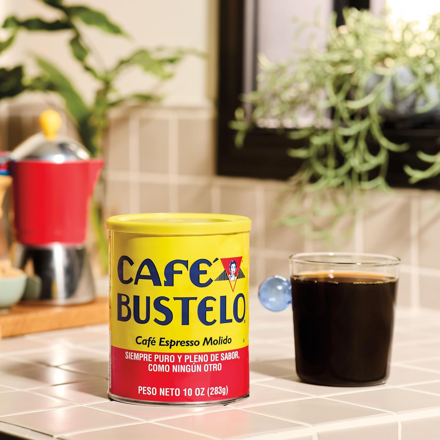Cafe Bustelo espresso ground coffee can beside a cup of black coffee on a kitchen counter